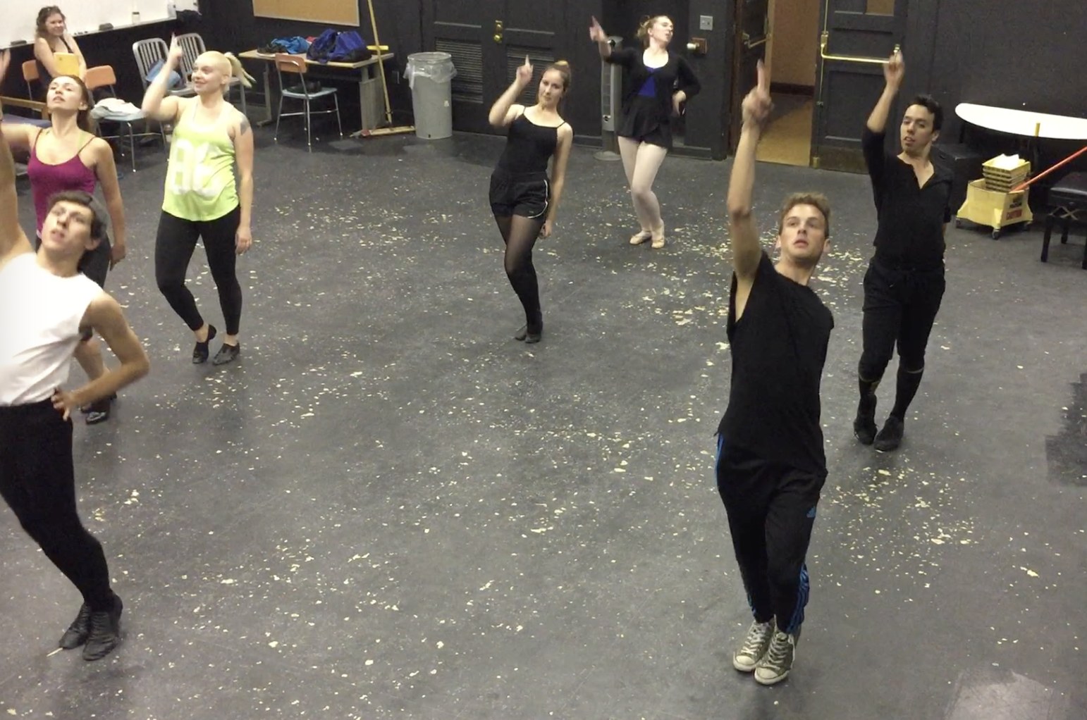 Group jazz dance rehearsal, performers reaching upward